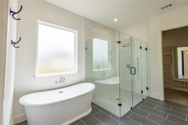 bathroom with tile patterned floors, separate shower and tub, and a healthy amount of sunlight