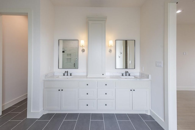 bathroom with tile patterned flooring, vanity, and a shower