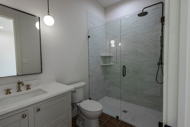 bathroom with toilet, an enclosed shower, and vanity