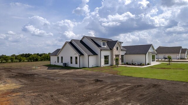 modern farmhouse featuring a front lawn and a garage