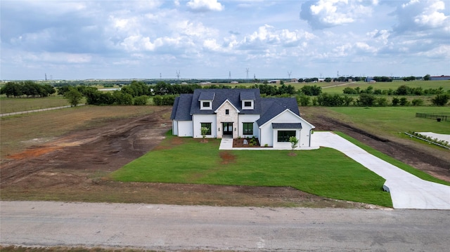 view of front of home with a front lawn, a rural view, and a garage