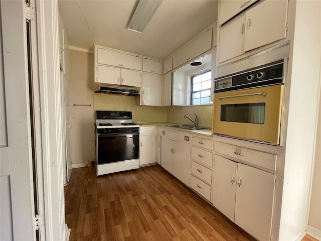 kitchen with sink, oven, white gas stove, and hardwood / wood-style floors