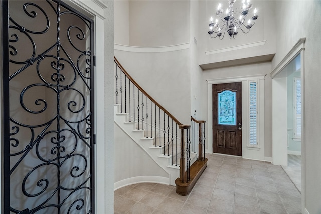 foyer with a high ceiling, light tile patterned flooring, and an inviting chandelier