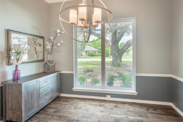 unfurnished dining area with dark wood-type flooring and a notable chandelier