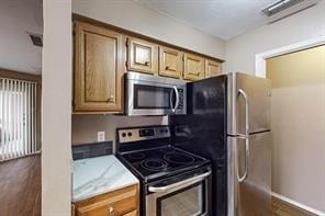 kitchen with stainless steel appliances and dark hardwood / wood-style flooring