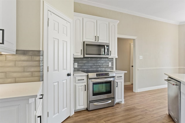 kitchen with white cabinets, stainless steel appliances, decorative backsplash, and light wood-type flooring