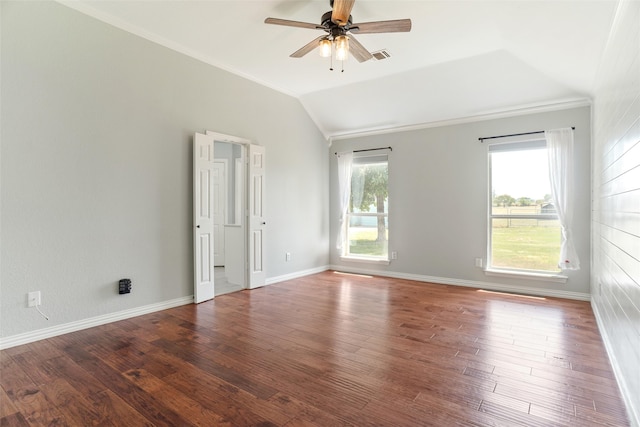 empty room featuring vaulted ceiling, plenty of natural light, and hardwood / wood-style floors