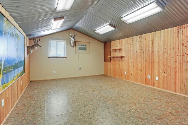 additional living space featuring lofted ceiling, tile patterned floors, wooden walls, and a wall mounted AC