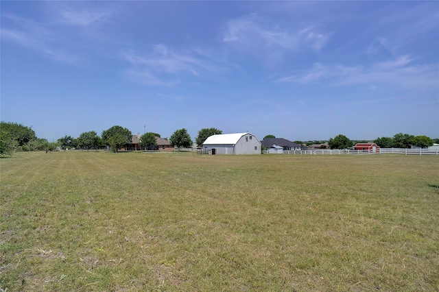 view of yard with a rural view and an outdoor structure