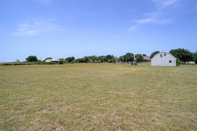 view of yard with a rural view and an outdoor structure