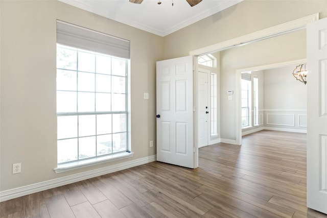 spare room with plenty of natural light, ceiling fan, light hardwood / wood-style flooring, and ornamental molding