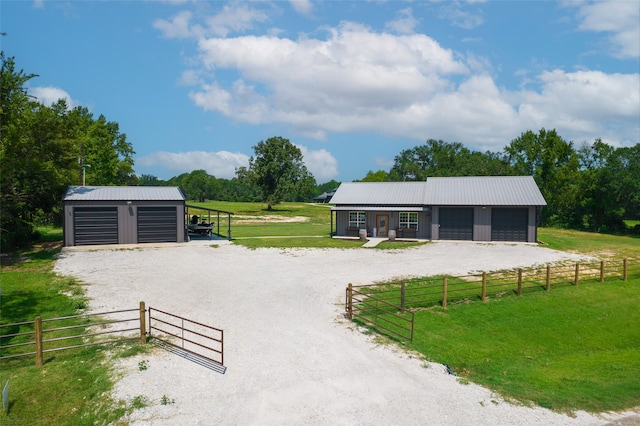 view of home's community with a yard, a detached garage, fence, and an outdoor structure