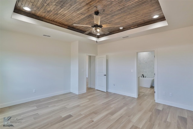 unfurnished bedroom featuring visible vents, wood ceiling, baseboards, a tray ceiling, and light wood finished floors