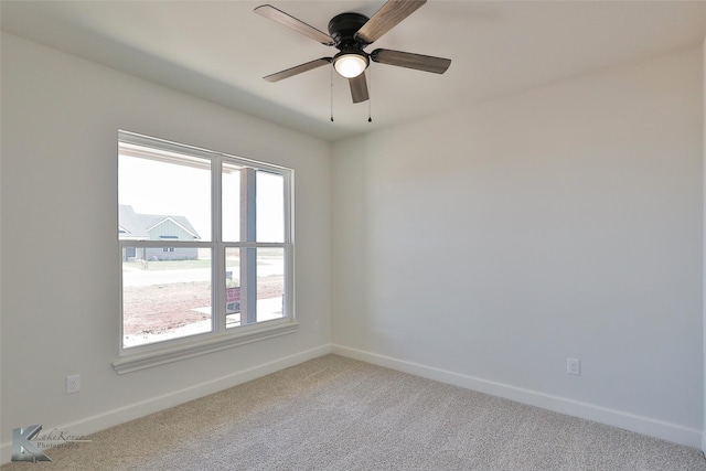 carpeted empty room with a ceiling fan and baseboards