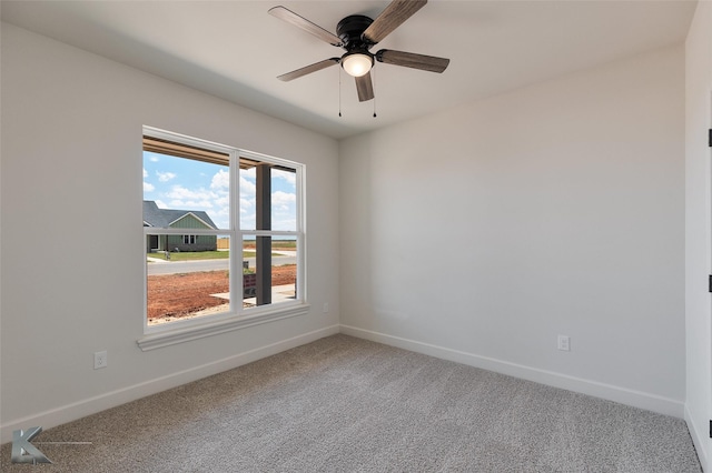 carpeted empty room with ceiling fan and baseboards