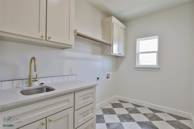 washroom featuring dark floors, hookup for a washing machine, a sink, cabinet space, and electric dryer hookup