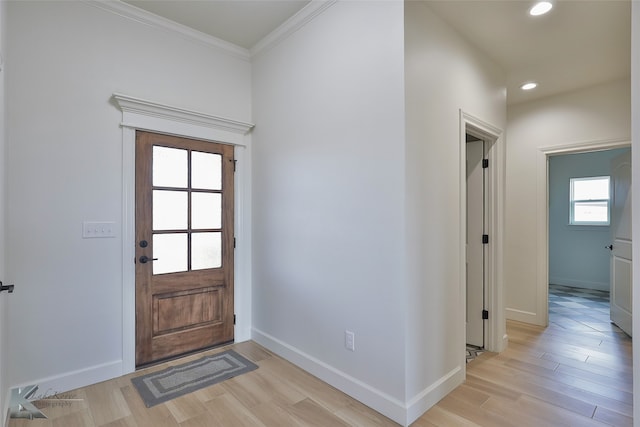 foyer featuring light wood-style flooring, baseboards, crown molding, and recessed lighting