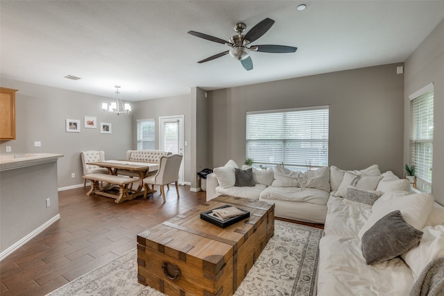 living room featuring ceiling fan with notable chandelier