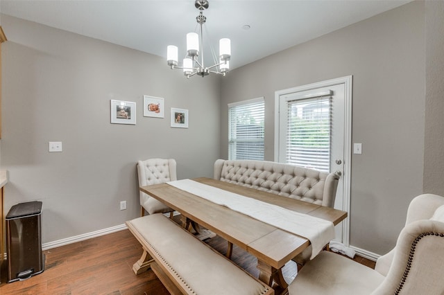 dining area featuring dark wood-type flooring and a chandelier