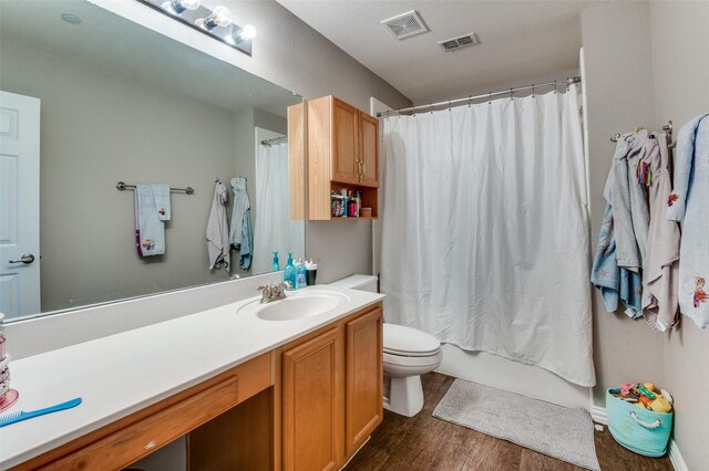 full bathroom featuring shower / bath combo with shower curtain, vanity, wood-type flooring, and toilet