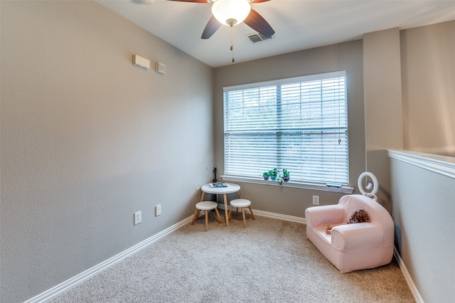 living area with carpet floors and ceiling fan