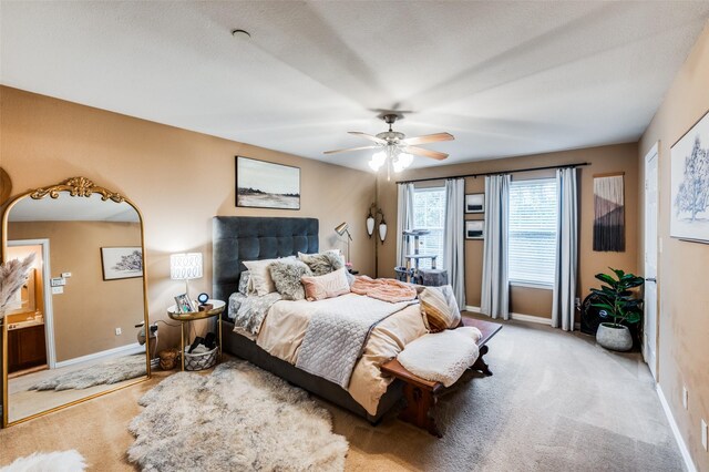 carpeted bedroom featuring connected bathroom and ceiling fan