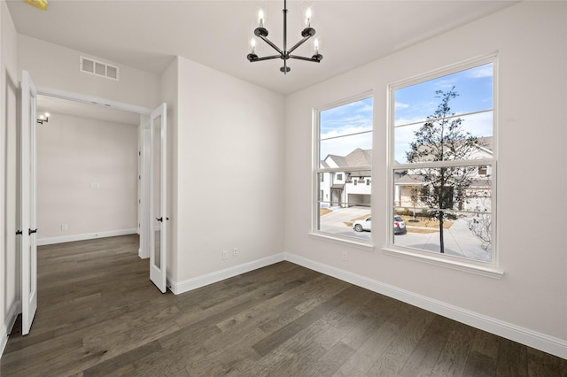 unfurnished dining area with an inviting chandelier and dark wood-type flooring