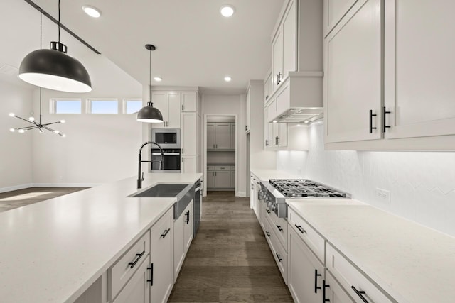 kitchen featuring sink, tasteful backsplash, appliances with stainless steel finishes, pendant lighting, and white cabinets