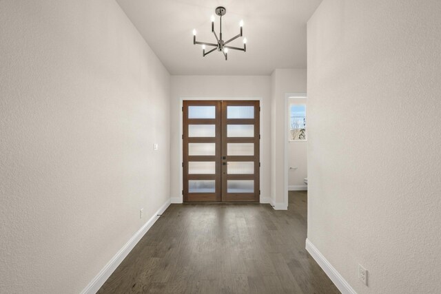 entryway featuring a notable chandelier, dark hardwood / wood-style floors, and french doors