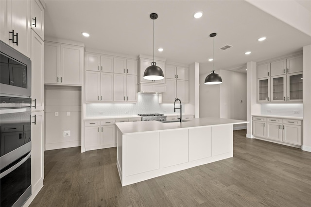 kitchen featuring a kitchen island with sink, white cabinetry, and sink