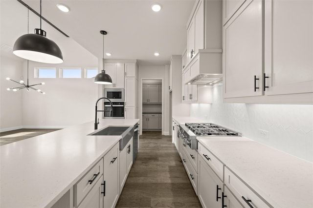 kitchen featuring hanging light fixtures, appliances with stainless steel finishes, sink, and white cabinets