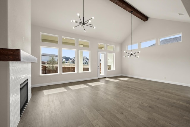 unfurnished living room with beam ceiling, a notable chandelier, dark hardwood / wood-style flooring, and a fireplace