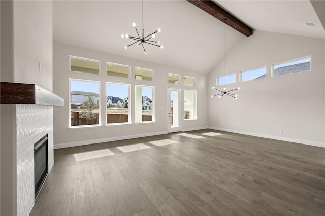 unfurnished living room featuring a tiled fireplace, dark hardwood / wood-style floors, and an inviting chandelier