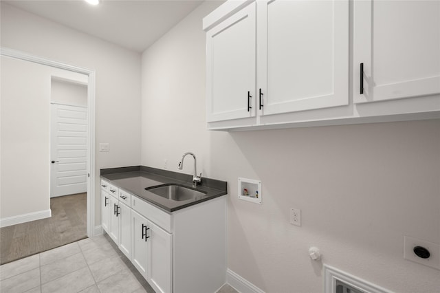 washroom featuring sink, washer hookup, cabinets, hookup for an electric dryer, and light tile patterned flooring