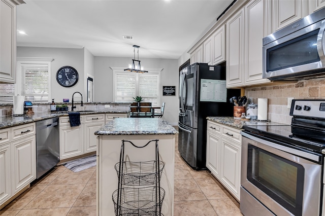 kitchen with stainless steel appliances, light tile patterned flooring, a peninsula, and decorative backsplash