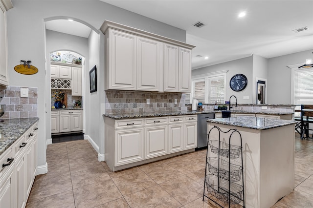 kitchen featuring visible vents, a sink, a peninsula, and stainless steel dishwasher