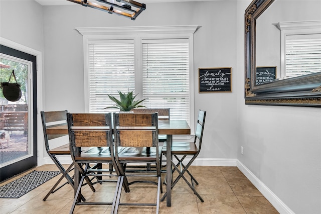 dining area with light tile patterned flooring and baseboards