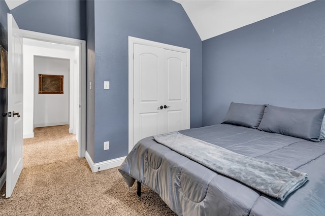 carpeted bedroom featuring vaulted ceiling, a closet, and baseboards