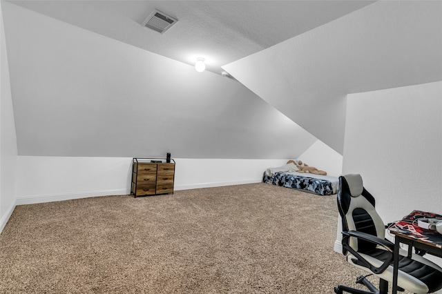 carpeted office featuring baseboards, visible vents, vaulted ceiling, and a textured ceiling