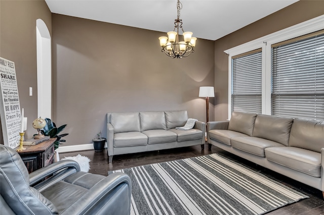 living area featuring a notable chandelier, wood finished floors, and baseboards