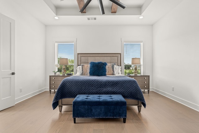 bedroom with ceiling fan, multiple windows, and light wood-type flooring