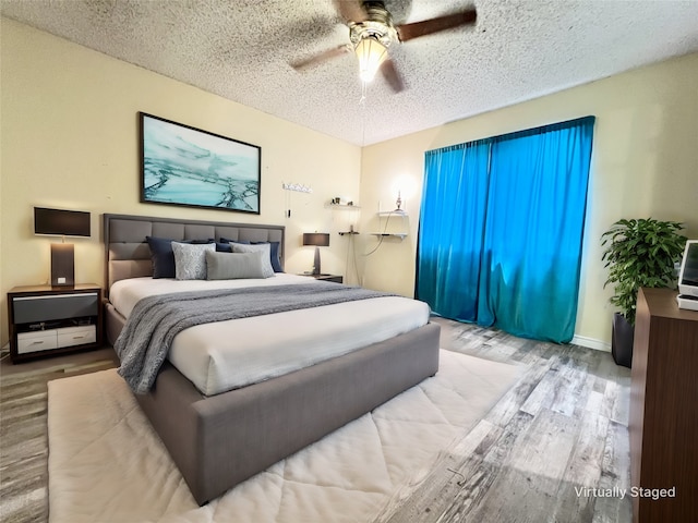 bedroom with hardwood / wood-style floors, a textured ceiling, and ceiling fan