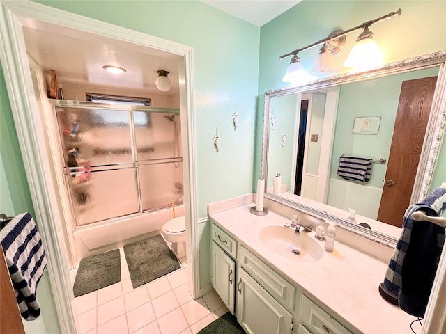 full bathroom featuring combined bath / shower with glass door, vanity, tile patterned flooring, and toilet