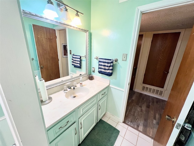 bathroom with a textured ceiling, vanity, and tile patterned floors