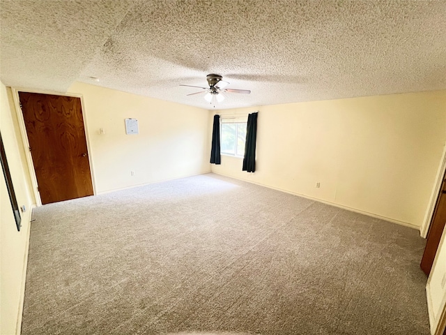 empty room featuring a textured ceiling, carpet floors, and ceiling fan