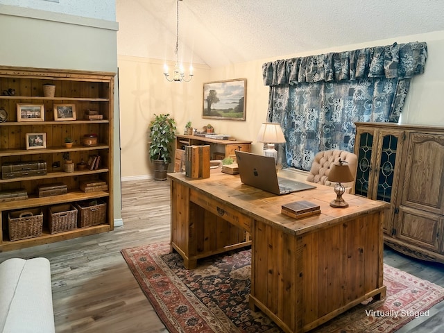 office featuring a notable chandelier, wood-type flooring, lofted ceiling, and a textured ceiling