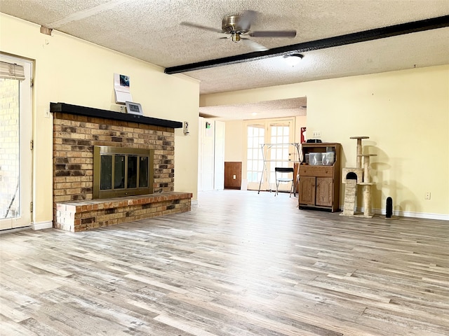 unfurnished living room with a textured ceiling, hardwood / wood-style flooring, and ceiling fan