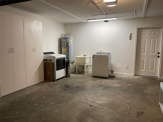 basement featuring washing machine and clothes dryer, sink, and water heater