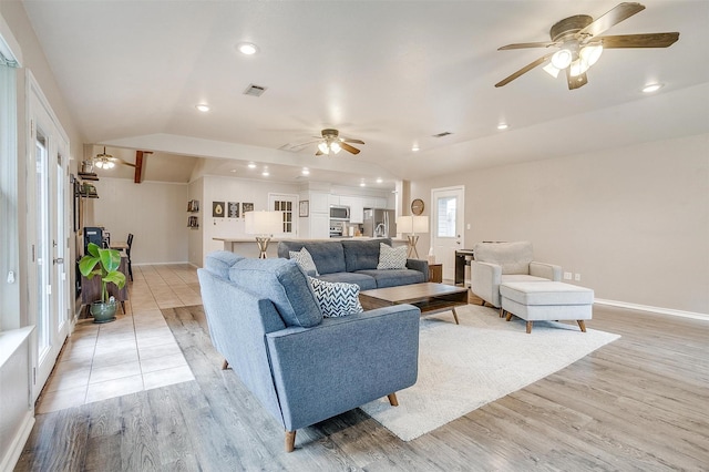 living room featuring ceiling fan, vaulted ceiling, and light wood-type flooring