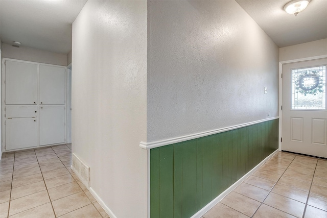 interior space featuring light tile patterned floors and wood walls